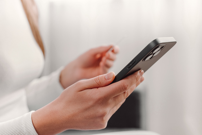 Close up of female hands holding phone in a mobile repair store